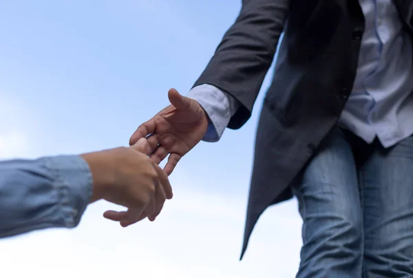 Ayuda concepto mano extendiéndose para ayudar a alguien con el cielo azul — Foto de Stock