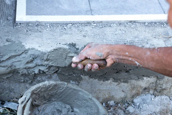 Homem moldando a borda em om o chão com espátula na construção — Fotografia de Stock