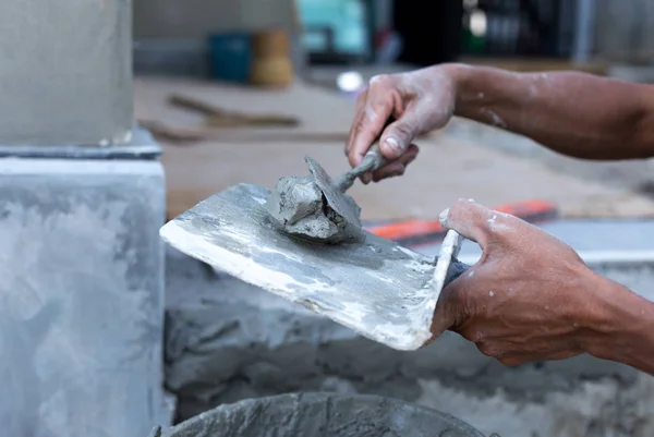 Unidentified man mixing mortar on a tray — Stock Photo, Image