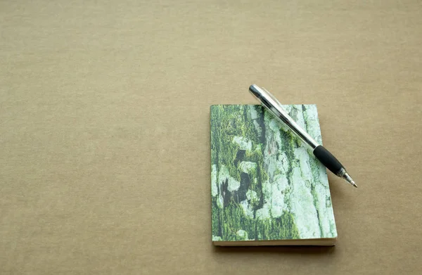 Anteckningsbok och penna på brunt papper — Stockfoto