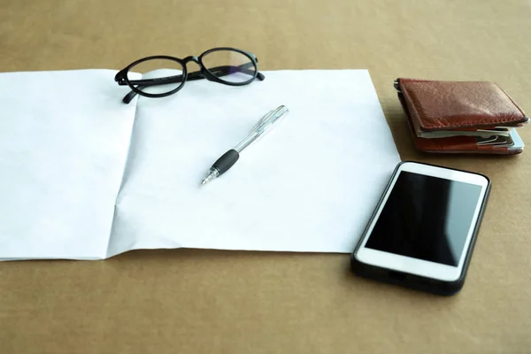 Valda fokus penna och plånbok, Glasögon och mobiltelefon med manu — Stockfoto