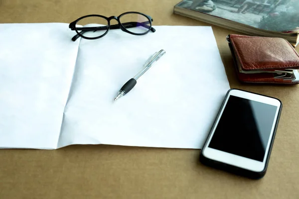 Valda fokus penna och plånbok, Glasögon och mobiltelefon med manu — Stockfoto