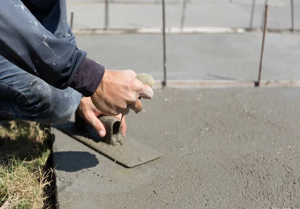 Trabalhador piso de concreto liso espremer esponja para molhar o concreto — Fotografia de Stock