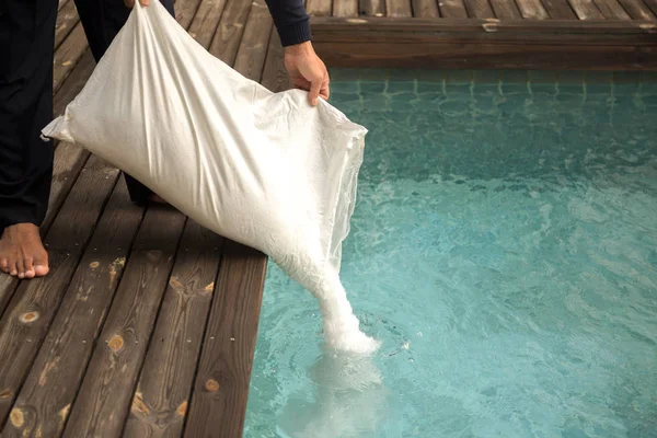 Man sätta salt kloreringsapparat för behandling vatten i simning poo — Stockfoto