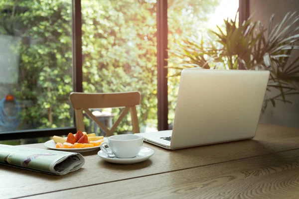 Tasse Kaffee und frisches Obst mit Zeitung auf dem Tisch und — Stockfoto