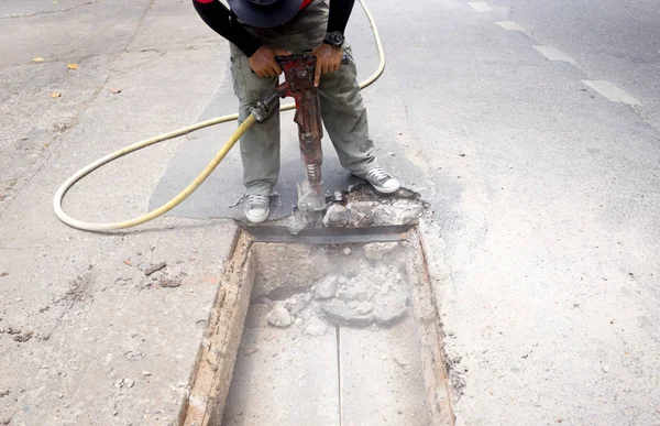 Trabajador trabajando en el sitio de la carretera demoliendo asfalto con neumático — Foto de Stock