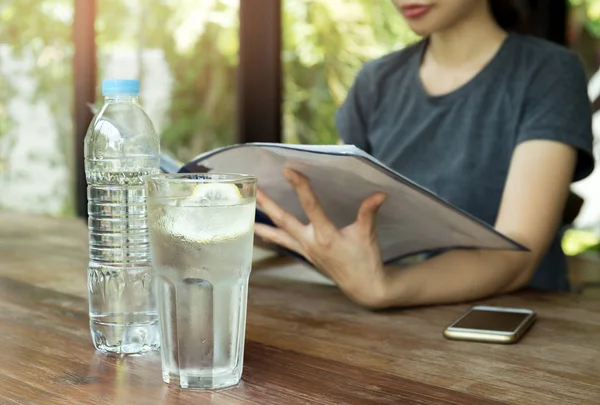 Verre d'eau fraîche avec tranche de citron et téléphone cellulaire allumé avec — Photo