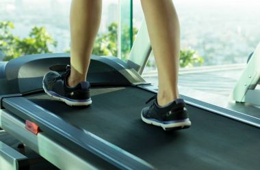 Spor salonunda treadmill egzersiz üzerinde yürüyen kadın 