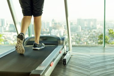Spor salonunda treadmill egzersiz üzerinde yürüyen kadın 