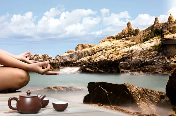 Mano de una mujer meditando en una pose de yoga en la playa rocosa por — Foto de Stock