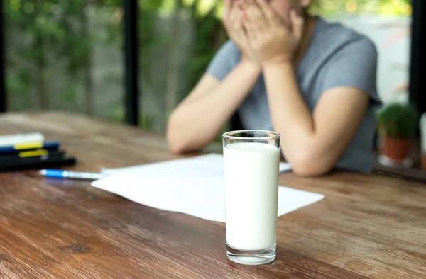 Ung kvinna falla sömn medan du läser en bok med glas mjölk — Stockfoto