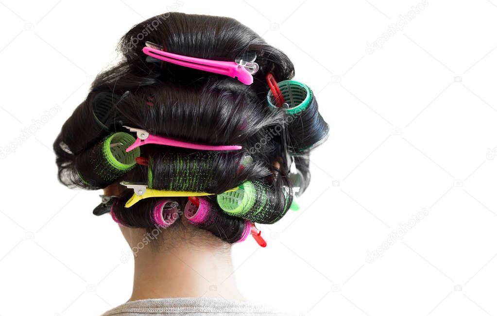 Back view asian woman with her hair in rollers isolated 