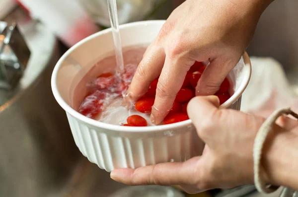 Lavage des tomates cerises fraîches à l'eau courante — Photo