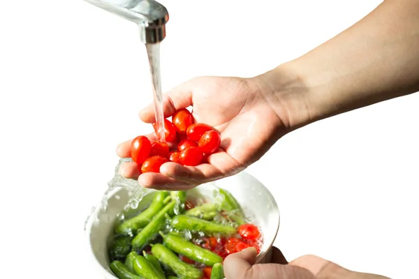 Mãos lavando tomates cereja frescos em água corrente isolada — Fotografia de Stock
