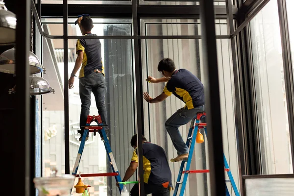 Pekerja tak dikenal menerapkan lapisan berwarna pada jendela kaca — Stok Foto