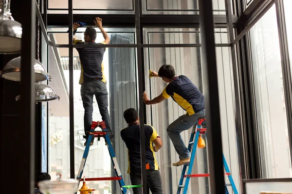 Azonosítatlan munkavállaló alkalmazása színezett réteg üveg ablak — Stock Fotó