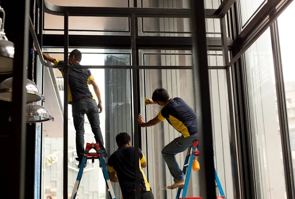 Trabalhador não identificado aplicando camada matizada na janela de vidro — Fotografia de Stock