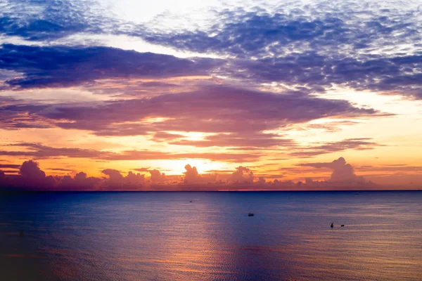 Salida del sol sobre el océano con barco de pesca y cielo colorido — Foto de Stock