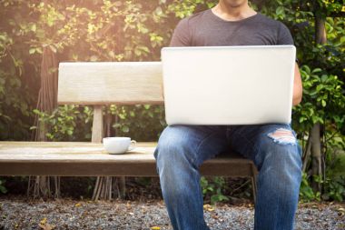 Jean ile bir dizüstü bilgisayarda çalışan kahve giyen adam sökük