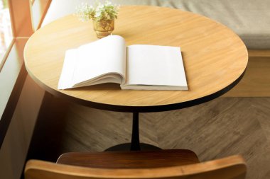 Bir açık kitap ve bitki penceresinde ahşap masa 