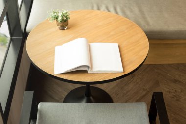 Bir açık kitap ve bitki penceresinde ahşap masa 