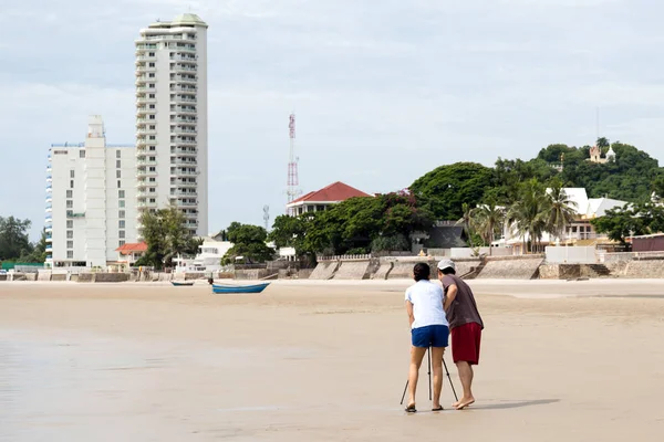 Coppia scattare foto utilizzando treppiede sulla spiaggia — Foto Stock