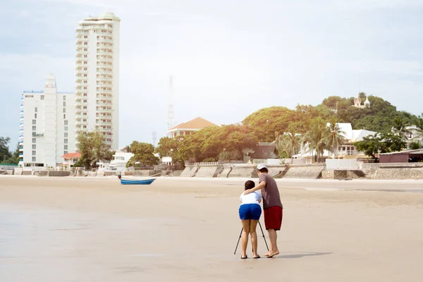 Coppia scattare foto utilizzando treppiede sulla spiaggia — Foto Stock