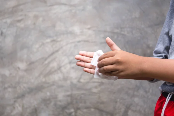 Młody chłopak czyszczenia ręce z wilgotną chusteczką przed uzyskaniem żywności — Zdjęcie stockowe