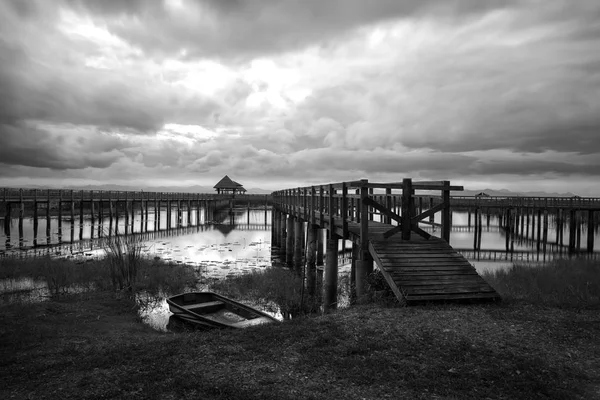 Black and white high contast lake with wooden bridge and boat in — Stock Photo, Image