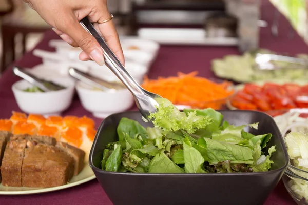 Выбранный фокус женщина берет свежий овощной салат из салата лук — стоковое фото