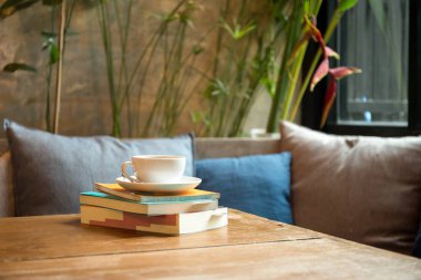 kahve fincanı ile kitap yığını 