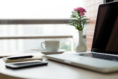 Seçilen odak fincan kahve ve pembe çiçekli laptop 