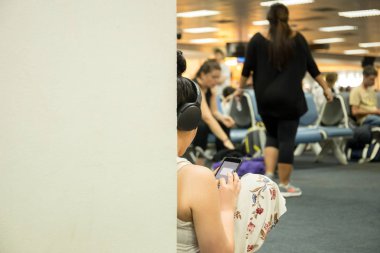 Seçilen Focus kadın kulaklık ile havaalanında oturan kullanarak