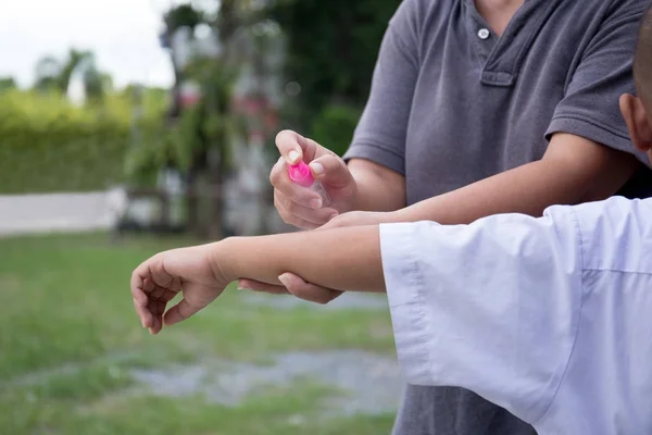 Madre rociando repelentes de insectos en el brazo de su hijo — Foto de Stock