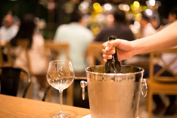 Shot in high iso with low light man hand grabbing bottle of wine — Stock Photo, Image