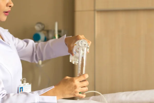Enfermeira dando água ao paciente usando seringa de vidro para irrigar nasog — Fotografia de Stock