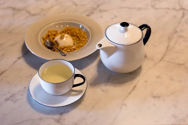 Cup of tea and tea pot with pudding on the table — Stock Photo, Image