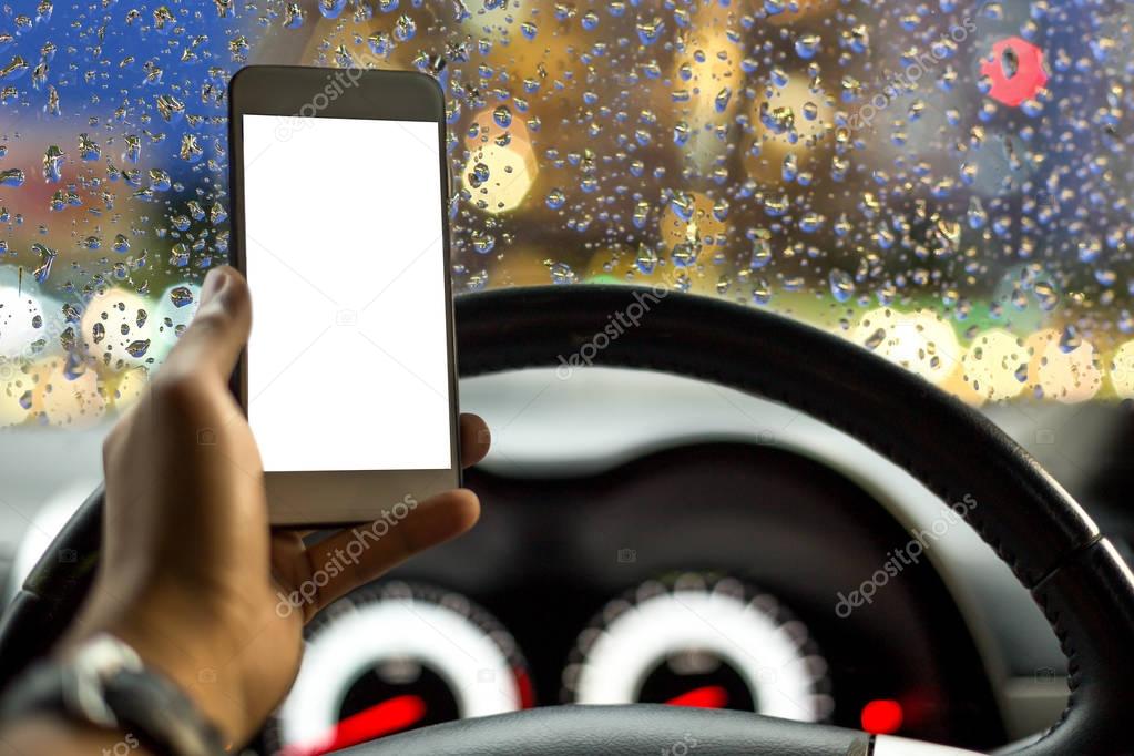 Danger concept man using cell phone while driving in rainy road
