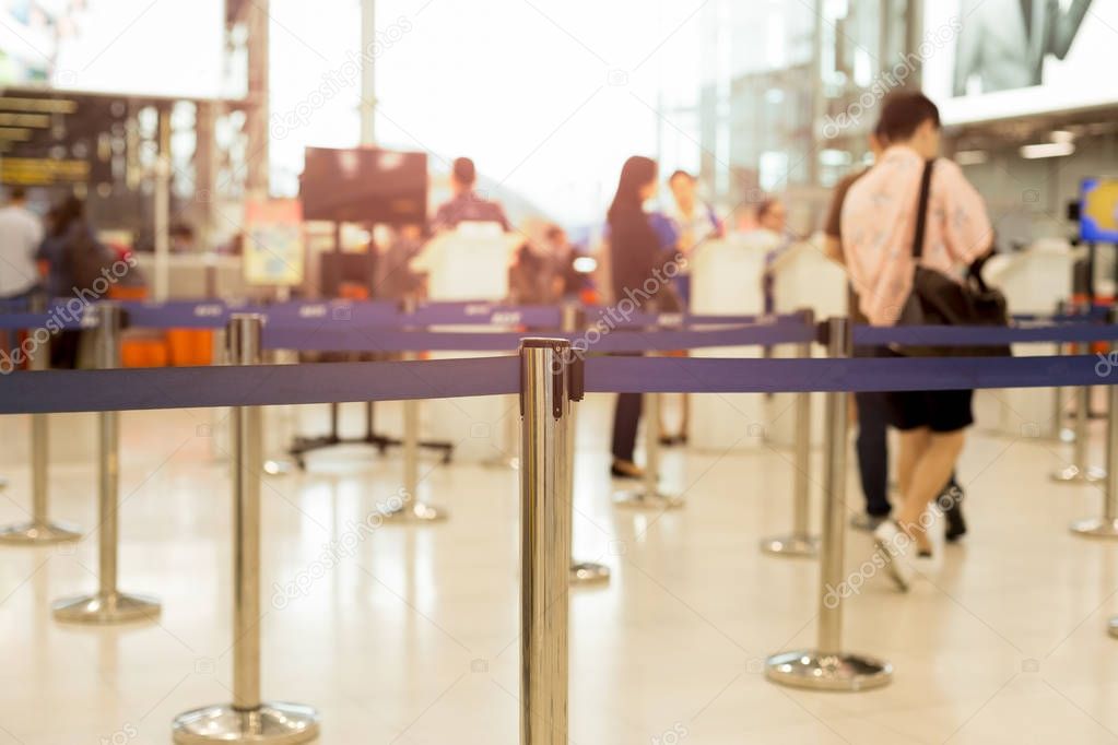 Passengers walking through check-in line at the airport 