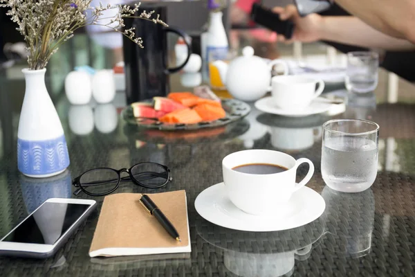 Cup of coffee and notebook with glasses pen with cell phone — Stock Photo, Image