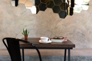 Kitap ve gözlük ve üzerinde yeşil bitki ile kavramsal kahve fincanı 