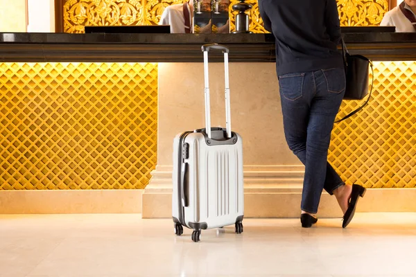 Bőrönd chek a recepción turisztikai nő — Stock Fotó