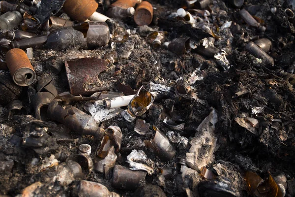 Broken glass bottles and garbage in burned trash — Stock Photo, Image