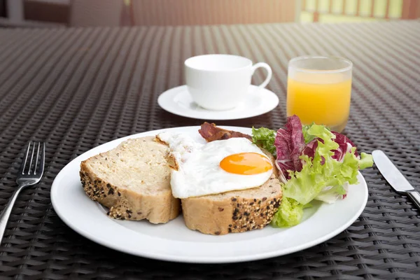 Frukost med stekt ägg, grönsaker, bröd, kaffe och apelsin — Stockfoto