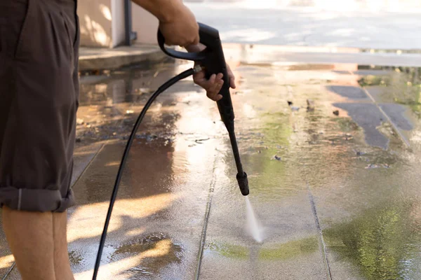 Mann reinigt Stein mit Hochdruck-Wasserstrahl — Stockfoto