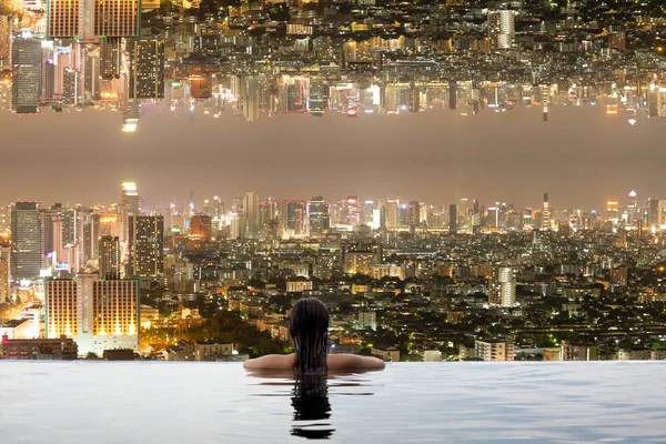 Підліток у басейні з містом догори ногами — стокове фото