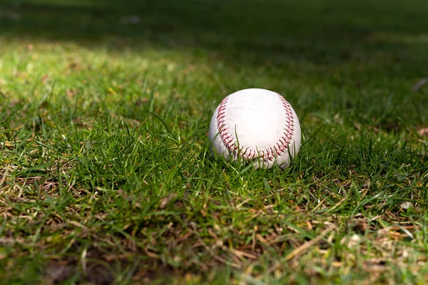 Yeşil çimenlerin üzerinde döşeme beyzbol kullanılan — Stok fotoğraf