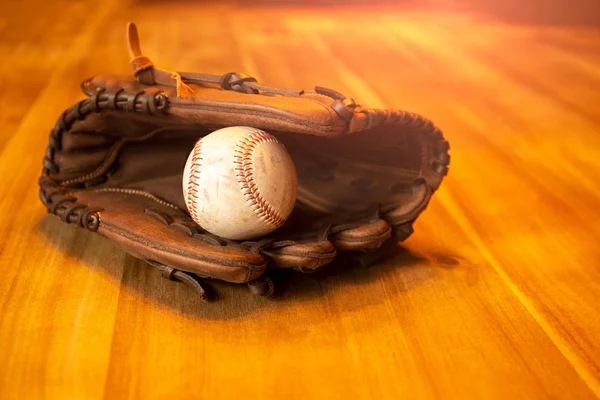 Baseball catcher mitt with ball on table — Stock Photo, Image