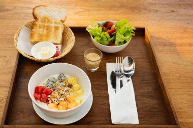 Sağlıklı kahvaltı kasesi yoğurtlu müsli ve meyveli tost, reçel ve sebze salatası..