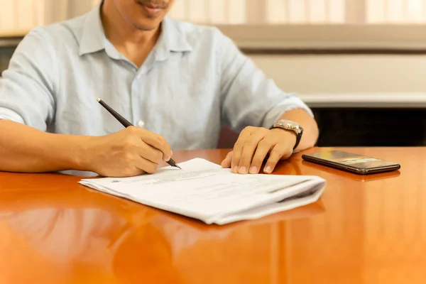 Empresario firmando documentos con pluma de pluma sobre escritorio de madera en casa . — Foto de Stock